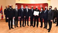 9 mężczyzn stoi podczas uroczystość węczenia promesy dla OSP