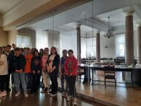 Grupa stoi przy lustrzanej ścianie