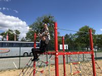 Chłopcy siedzą na ściance wspinaczkowej