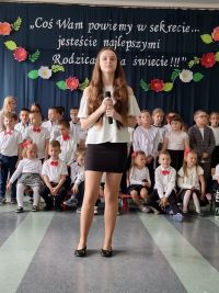 Dziewczyna w długich włosach, w rękach trzyma mikrofon