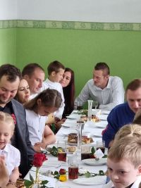 Rodzice z dziećmi siedzą przy stołach