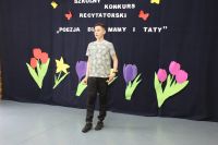 Chłopak w ciemnych spodniach i biało-czarnej bluzce