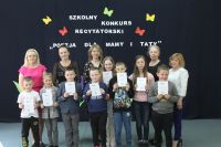 Grupa młodszych dzieci z dyplomami, z tyłu stoi pięć kobiet