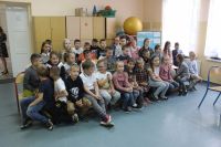 Grupa dzieci siedzi na krzesłach