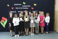 Grupa młodzieży z dyplomami, wśród nich stoją nauczycielki