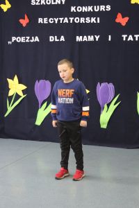 Chłopiec w niebieskiej bluzce i czarnych spodniach