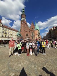 Uczniowie z opiekunami i przewodnikiem na tle Ratusza we Wrocławiu