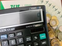 kalkulator, obok pieniądze