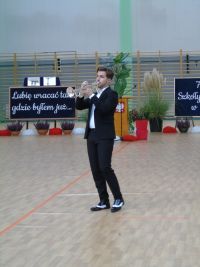 mężczyana w garniturze gra na trąbce